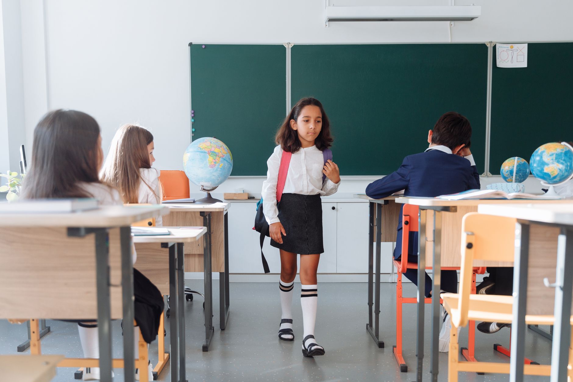 Students in a classroom interacting, showcasing a diverse learning environment.