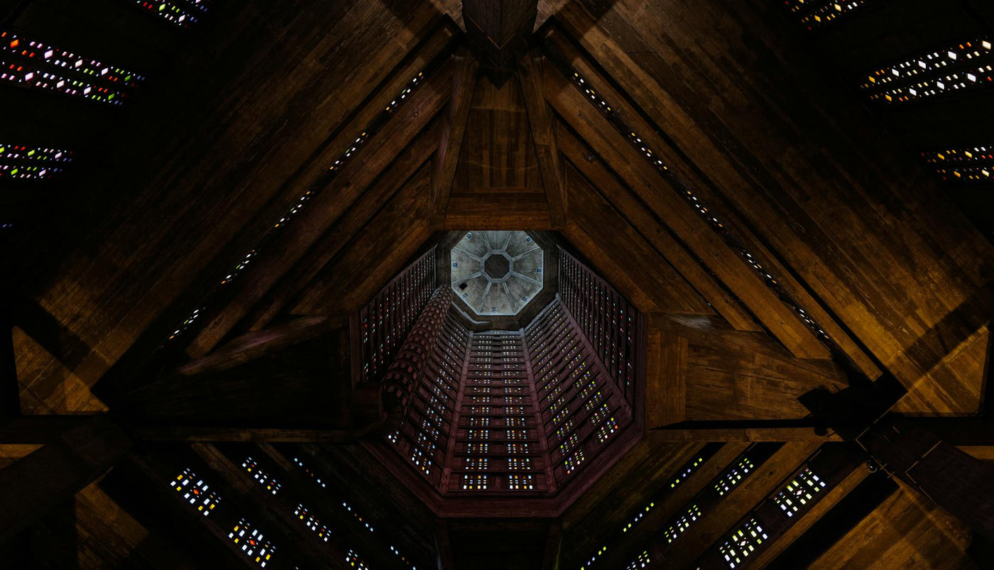 A dramatic view of a hexagonal ceiling with colorful stained glass effects, intricate architectural details.