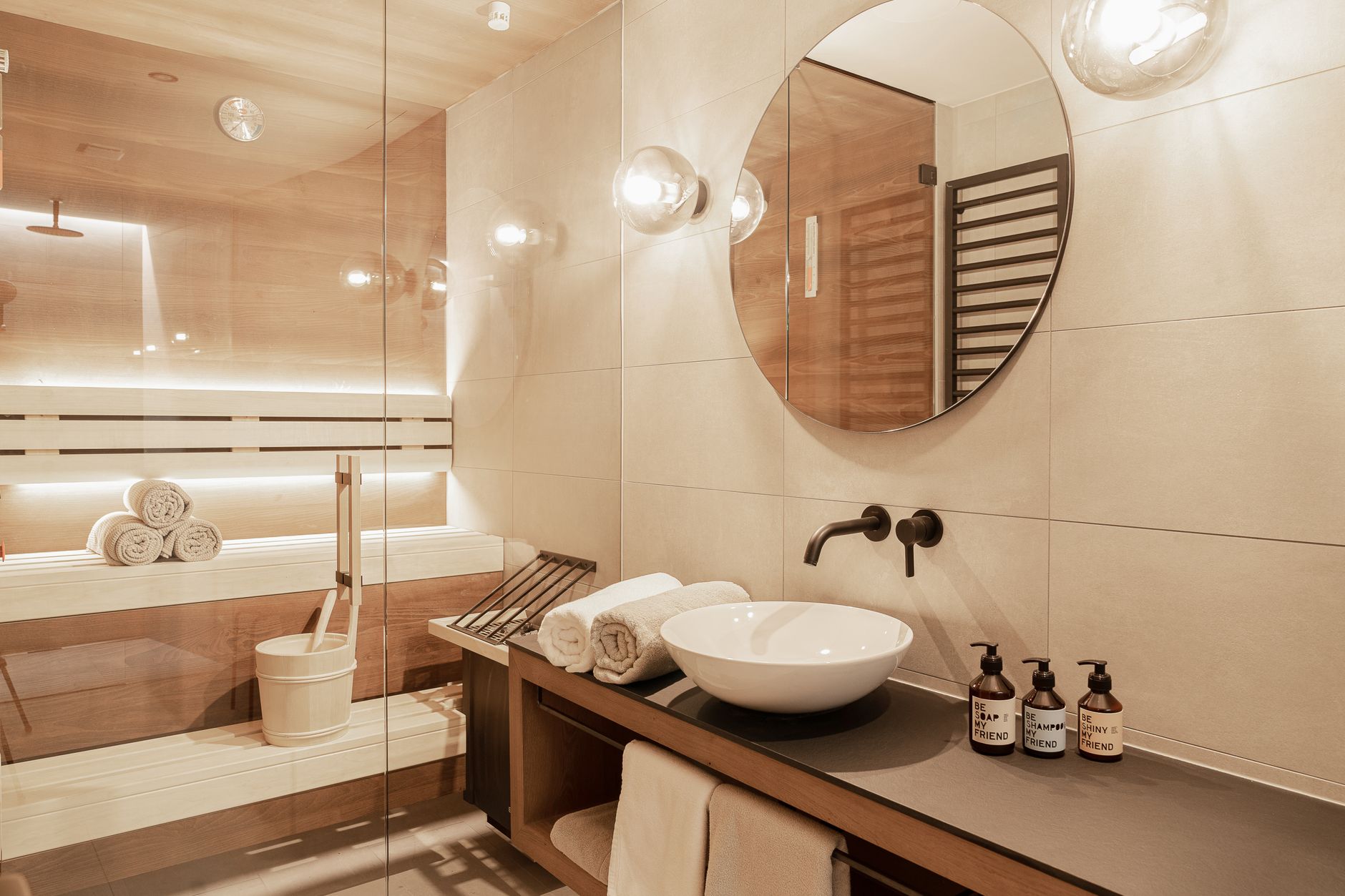Luxurious hotel bathroom featuring a sauna, elegant mirror, and spa amenities.