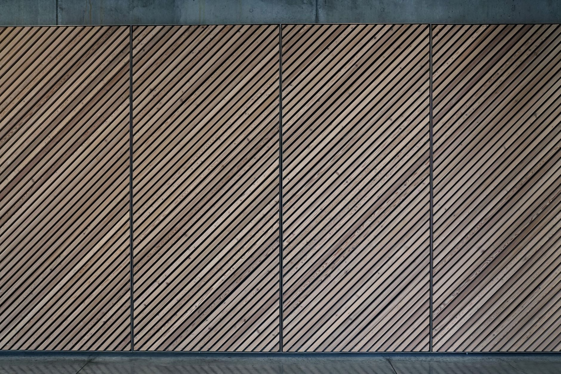 Abstract view of a diagonal wooden panel wall with a textured, patterned design.