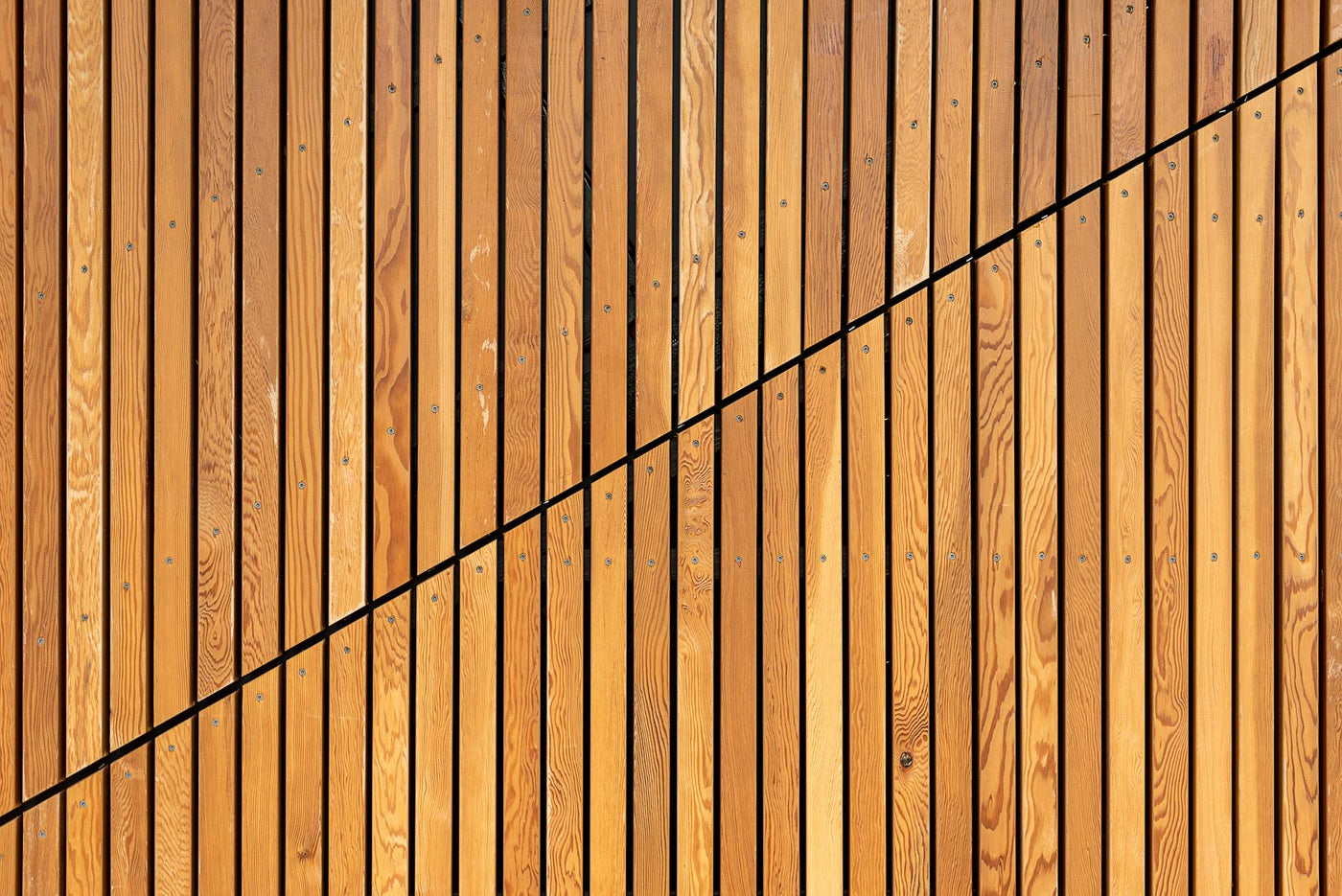 A close-up of wooden slats creating a modern diagonal pattern, ideal for backgrounds.