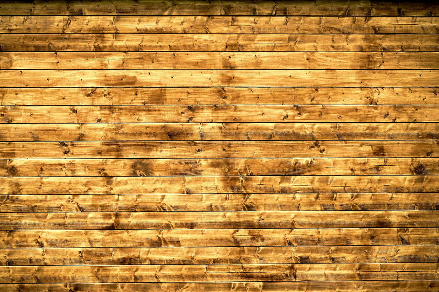 Textured wooden planks forming a rustic wall, perfect for backgrounds or design elements.