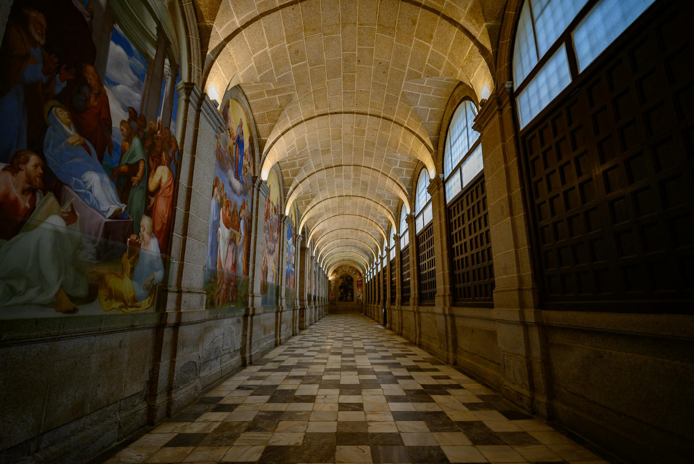 Gorgeous corridor with arched stone ceilings and mural paintings in a Madrid landmark.